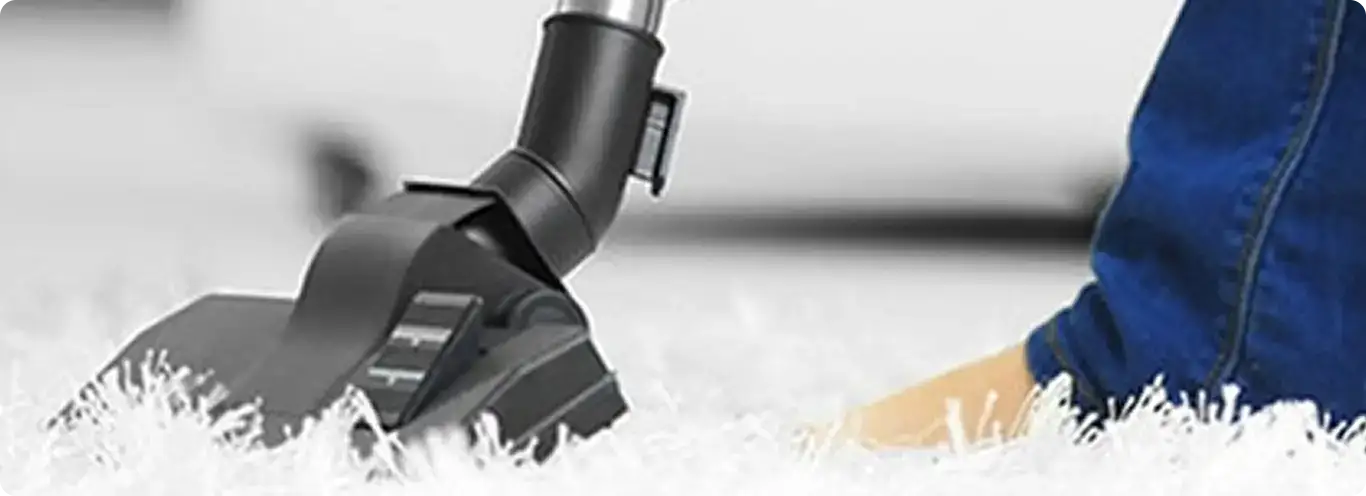 Close-up of a professional vacuuming a white carpet in Henderson.